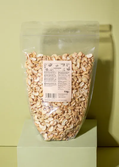 eine Plastiktüte mit cashewkernen steht auf einem grünen Ständer